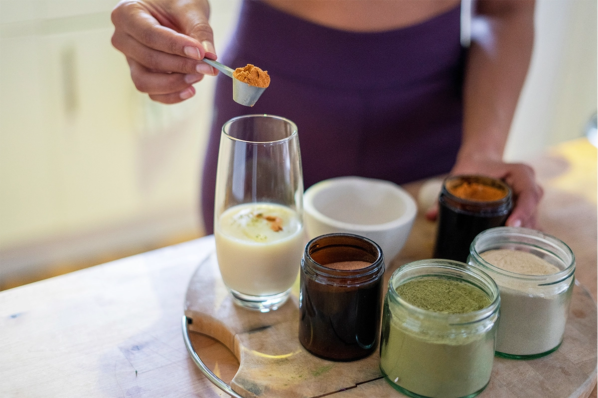 Woman preparing healthy drink at home.